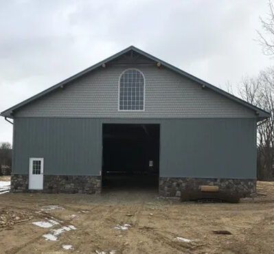 A large barn with a door open on the side.