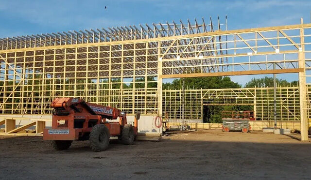 A large crane is parked in front of a building.